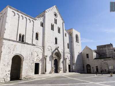 Sempre affollato di turisti e fedeli, lo spiazzo � circondato, oltre che dal maestoso luogo di culto simbolo di Bari con la sua facciata romanica sobria e possente... 
